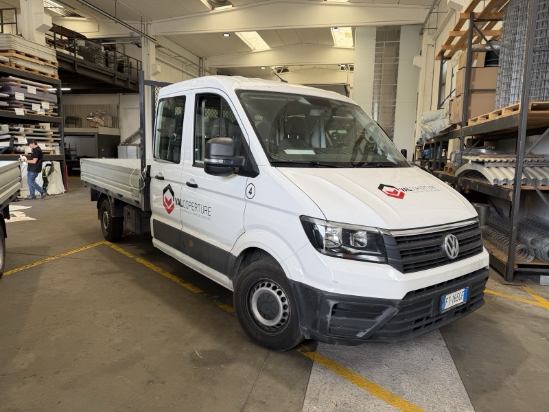 Autocarro Volkswagen bianco a doppia cabina con loghi Valcoperture sulle portiere e sul cofano.